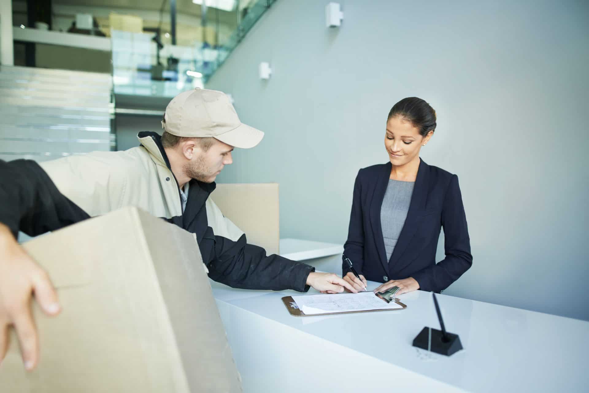 Delivery man dropping off a package at front of house reception