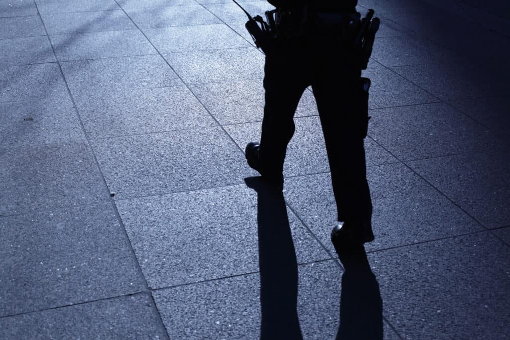 Mobile security guard walking across paved floor - employed by Security Patrol company